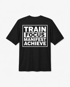 A black short-sleeve t-shirt with a bold white graphic print on the front reading 'TRAIN FOCUS MANIFEST ACHIEVE' inside a rectangular border, shown against a light gray background.